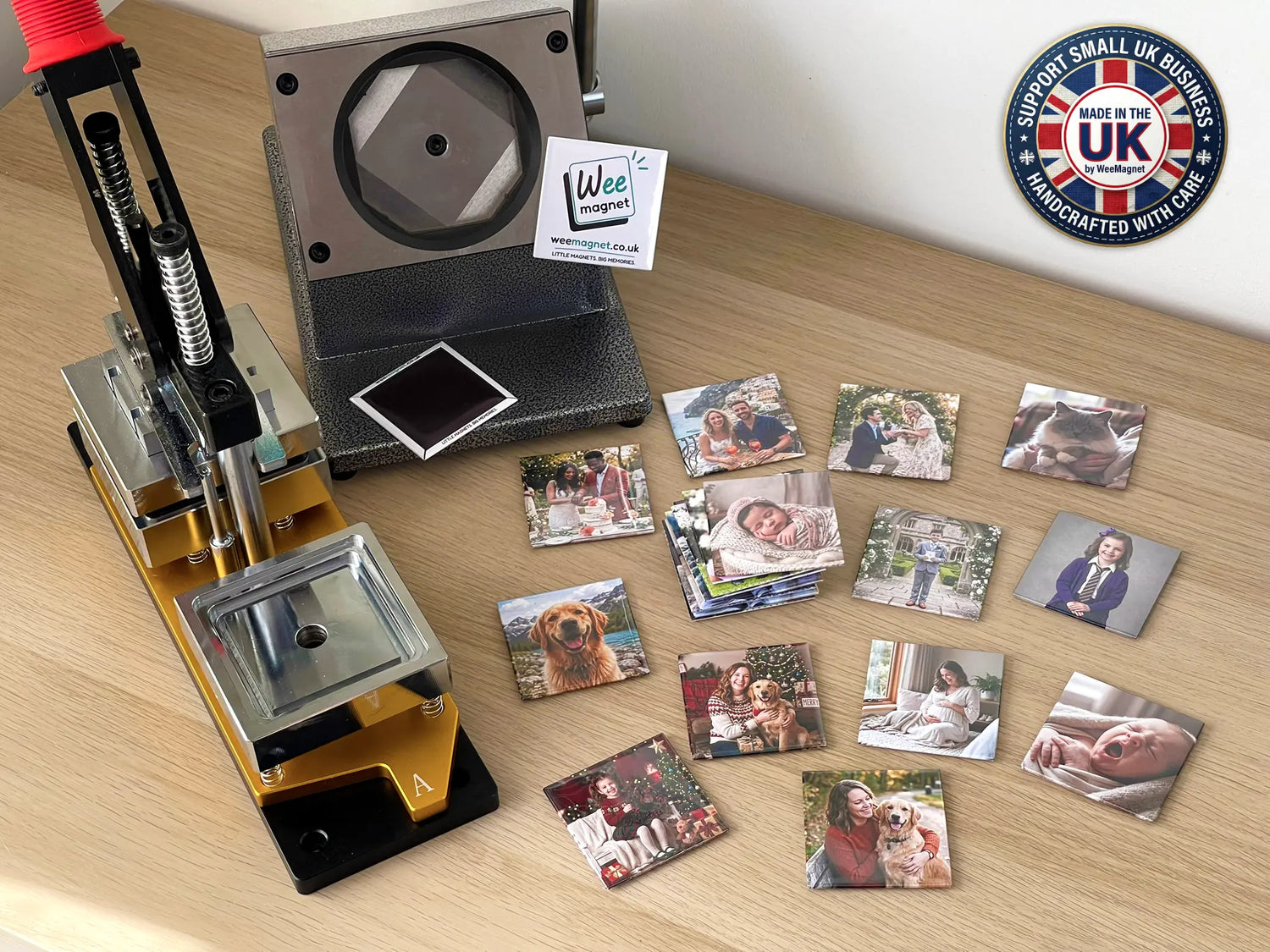 A handmade production setup showing a magnet press machine and several finished custom square photo magnets, with one magnet flipped upside down to reveal its thick, full-coverage black magnetic backing.
